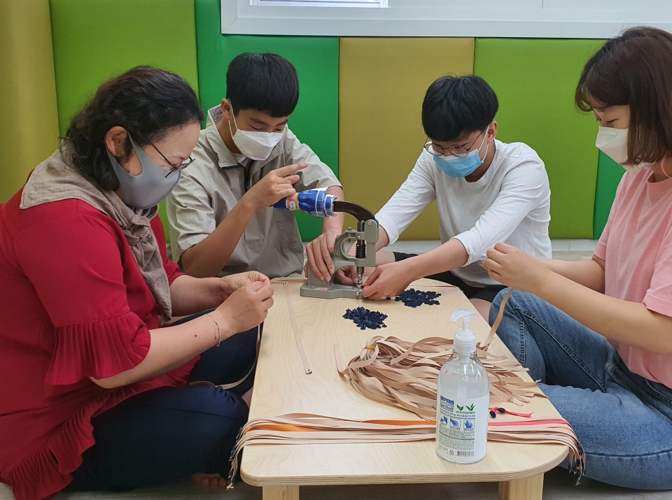 자원봉사자들이 마스크 목걸이를 만들고 있는 모습. 홍성교육지원청 제공