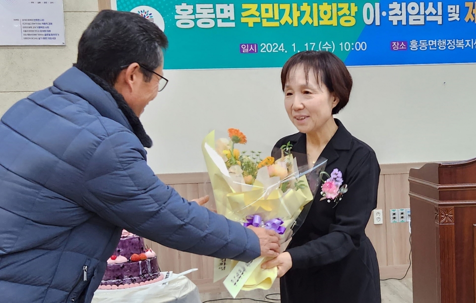 홍동면 주민자치회 제3기 회장으로 취임한 김화영 회장(오른쪽)이 꽃다발을 받고 있다. 사진=이번영 시민기자