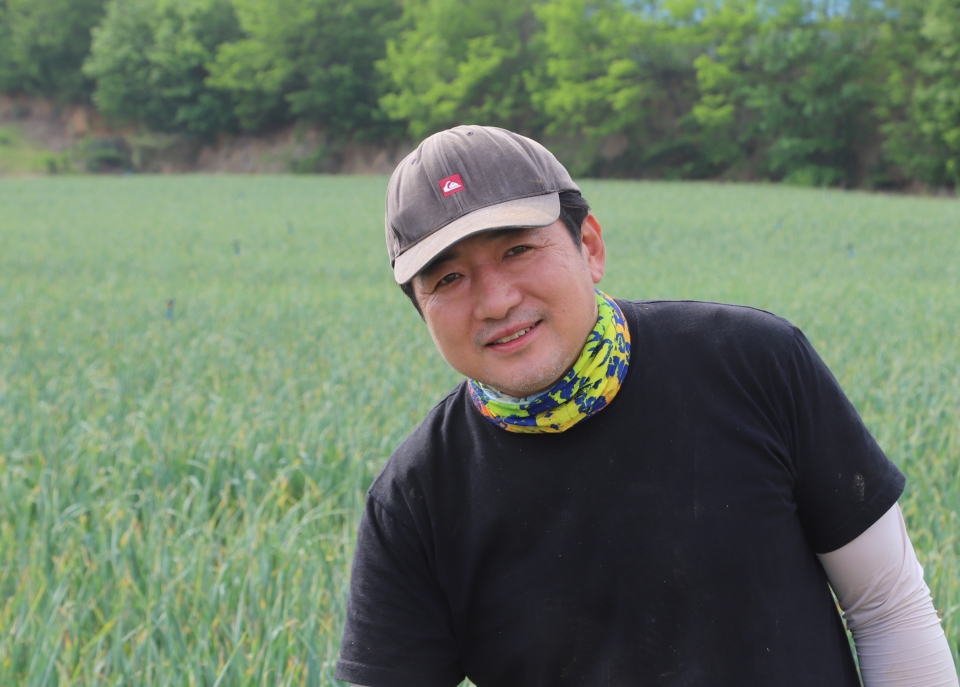 홍산마늘연구회 이성준 회장. 자신의 마늘밭에서 지접재배한 홍산마늘을 가리키며 우수성을 설명하고 있다. 사진=황동환 기자